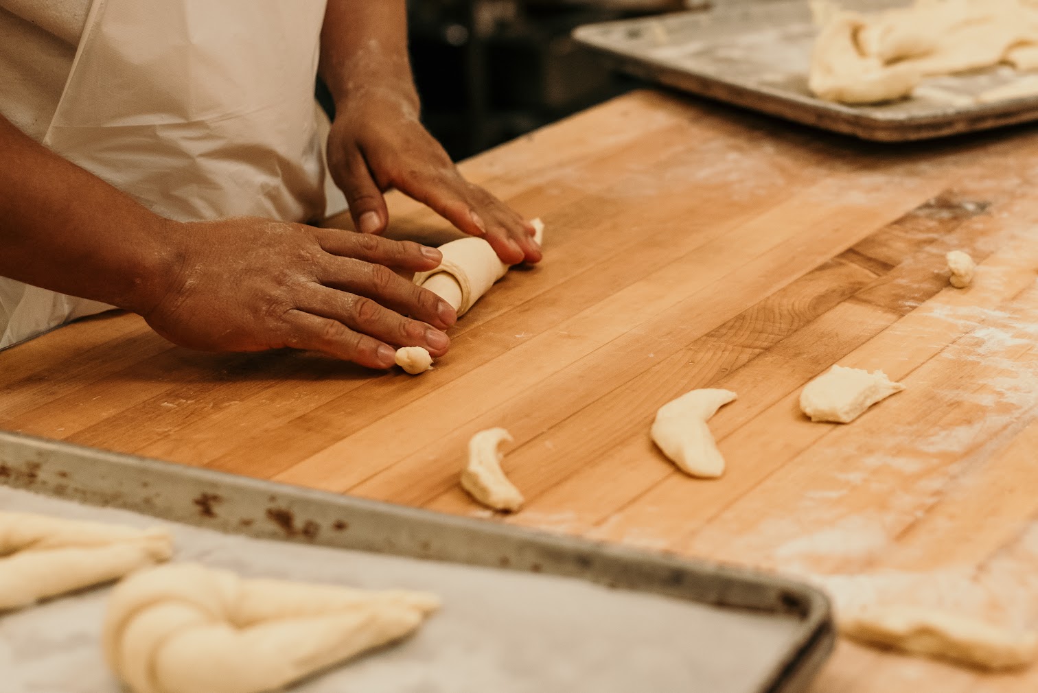 Baker rolling croissant dough